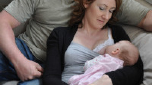Dad with mum who's practising laid-back breastfeeding