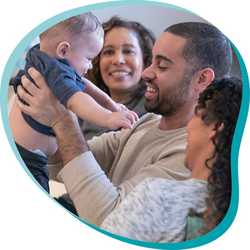 Dad holding up baby next two two women