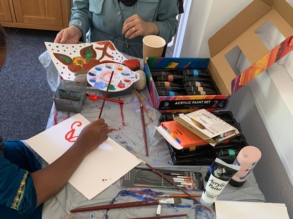 Two people painting at a craft table