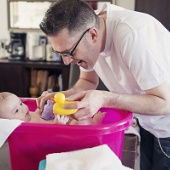 Dad bathing baby