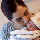 Parent kissing baby on their head after birth