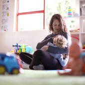 Parent breastfeeding child in playroom