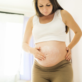 Pregnant woman or person applying moisturiser to skin