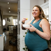 Pregnant woman eating in the kitchen