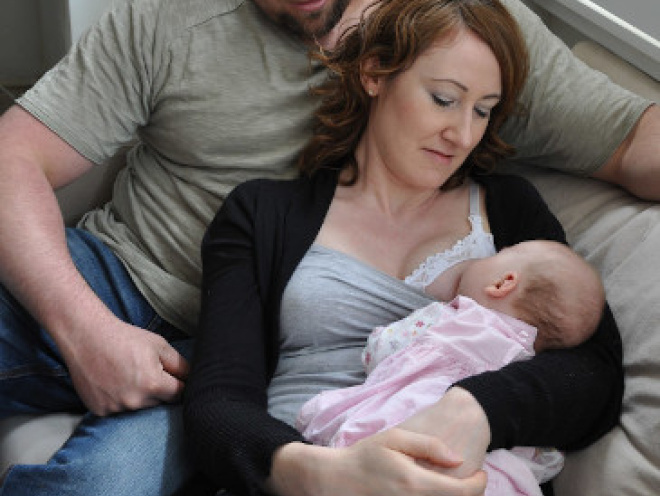 Dad with mum who's practising laid-back breastfeeding