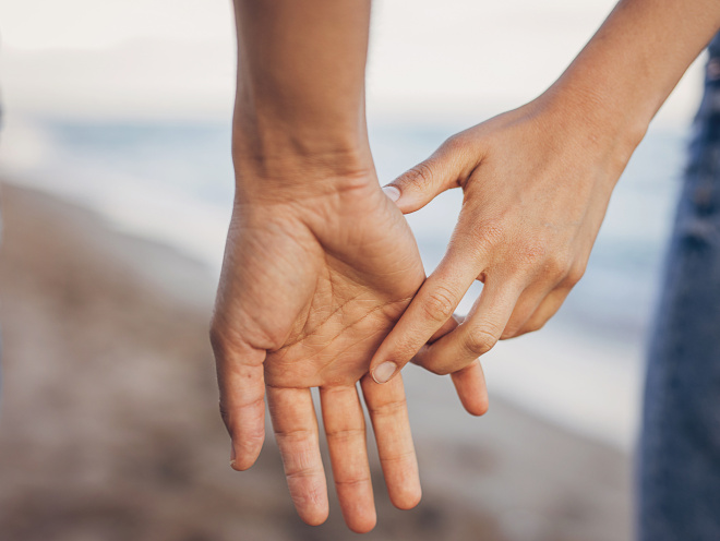 Couple holding hands on beach