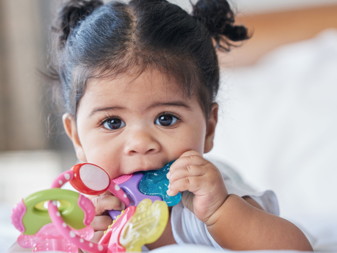 Young baby chewing on a teething ring