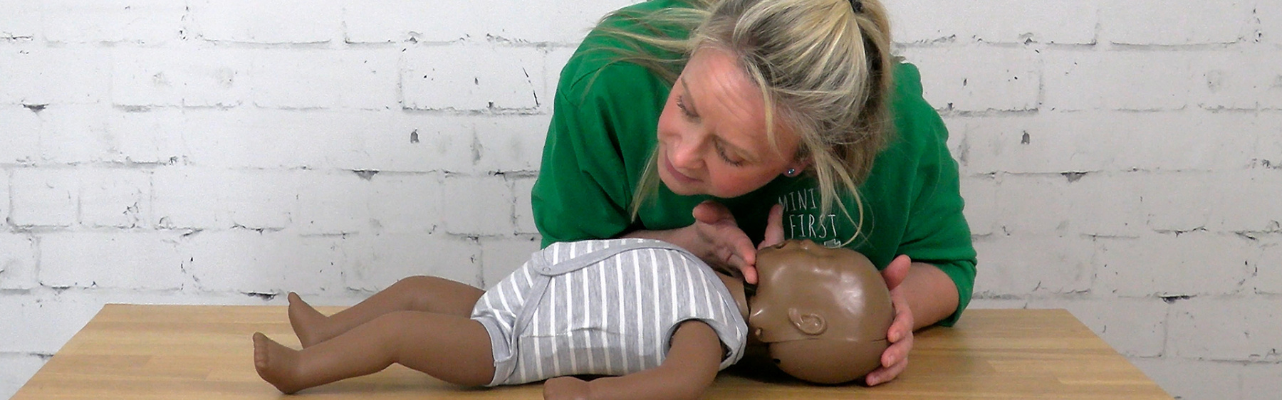 A person checking a baby doll for a heartbeat