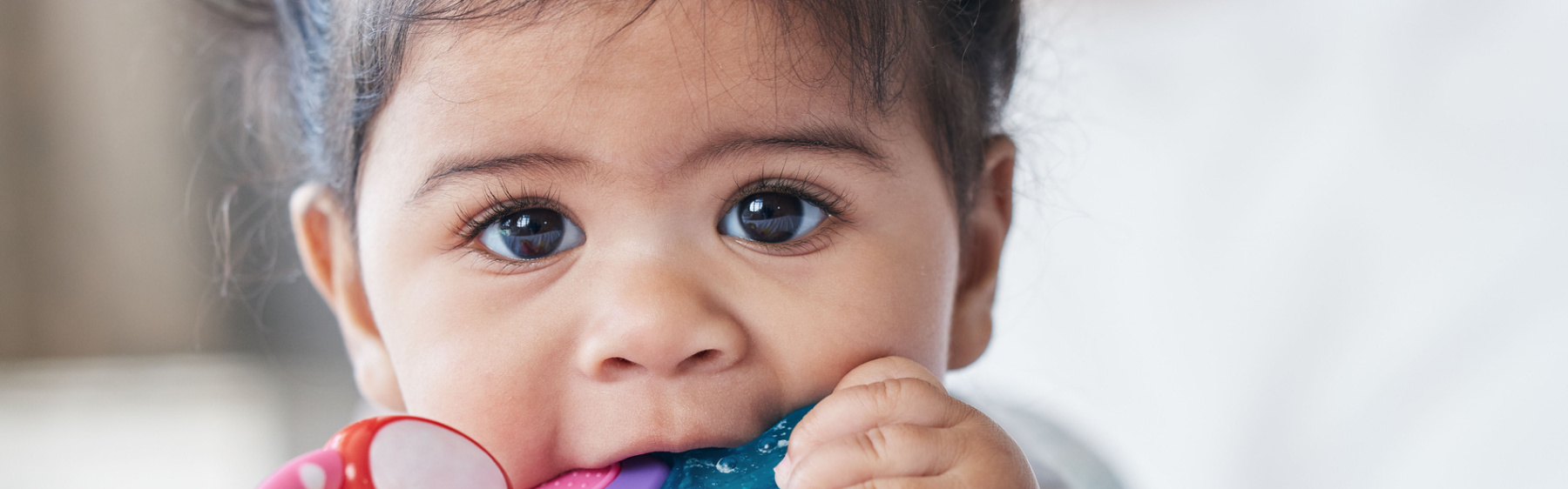 Young baby chewing teething ring