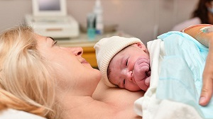 Woman holding baby after birth