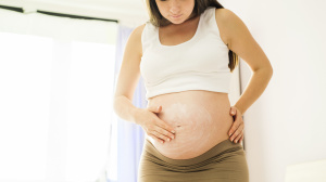 Pregnant woman or person applying moisturiser to skin