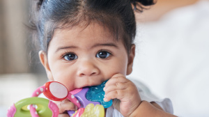 Young baby chewing on a teething ring