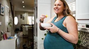 Pregnant woman eating in the kitchen