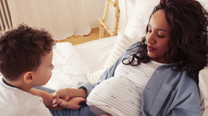 Pregnant woman lying down with toddler